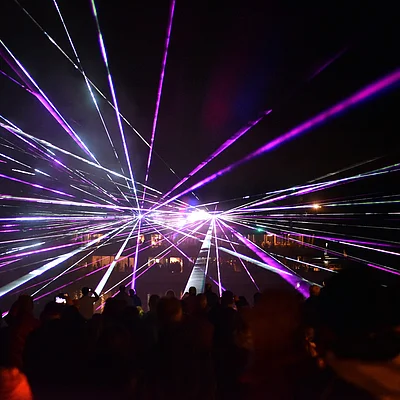 Bunte Laserstrahlen erleuchten den nächtlichen Himmel über den Brombachsee