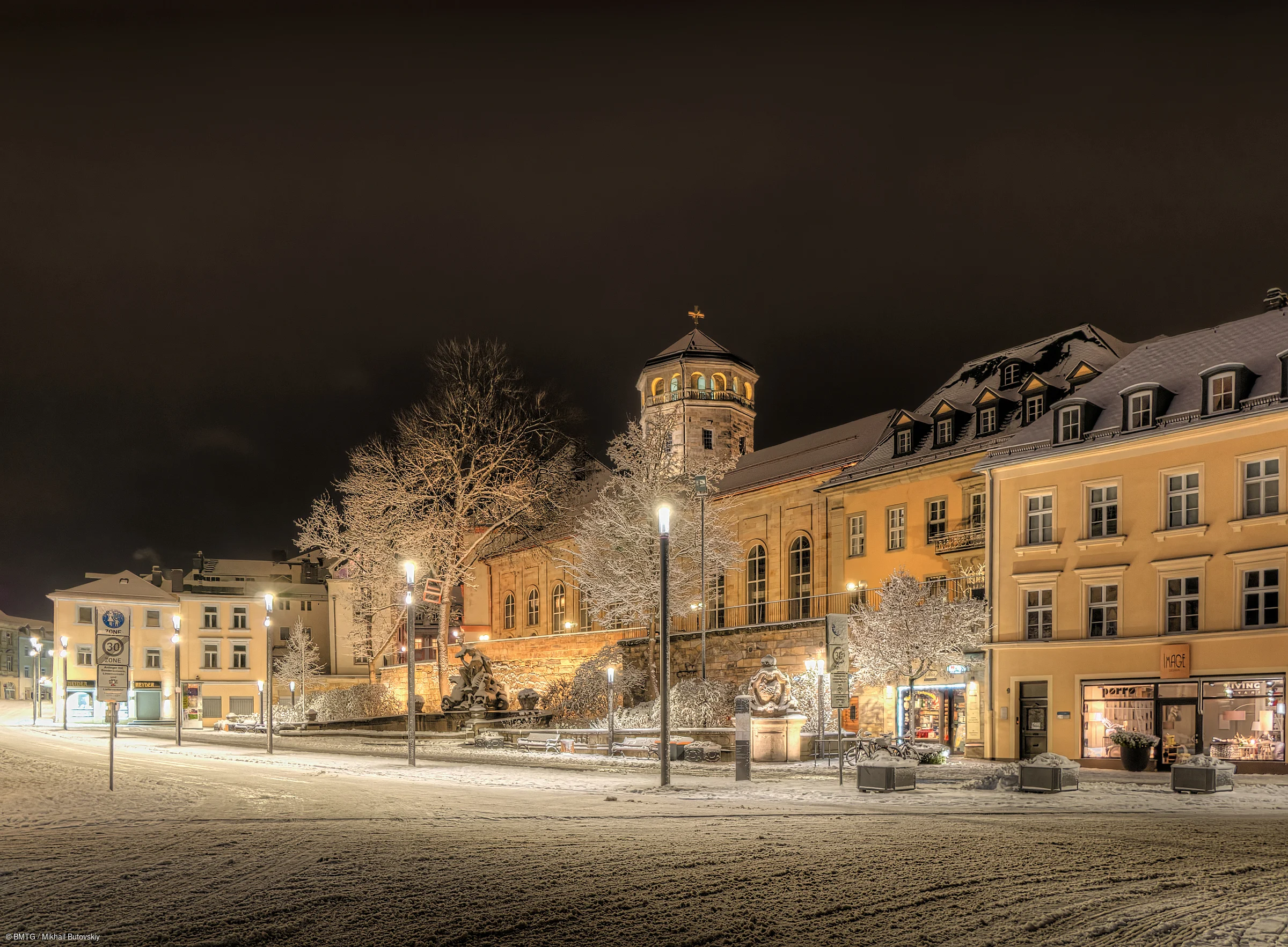 Verschneite Opernstraße mit Schlosskirche im Winter am Abend