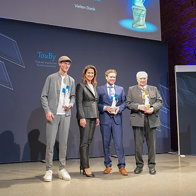 Staatsministerin Michaela Kaniber und die Preisträger des TouBy 2025 (v.l.) Marc-André Janz, Daniel Weickel sowie Karl Zettl.
