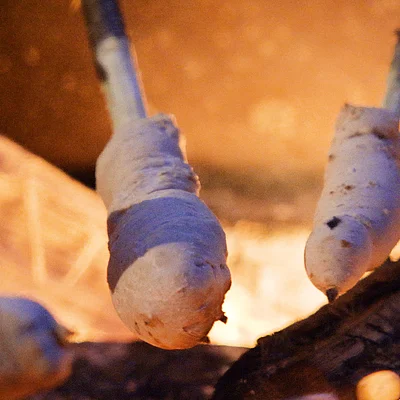 Stockbrot wird über offenem Feuer geröstet.
