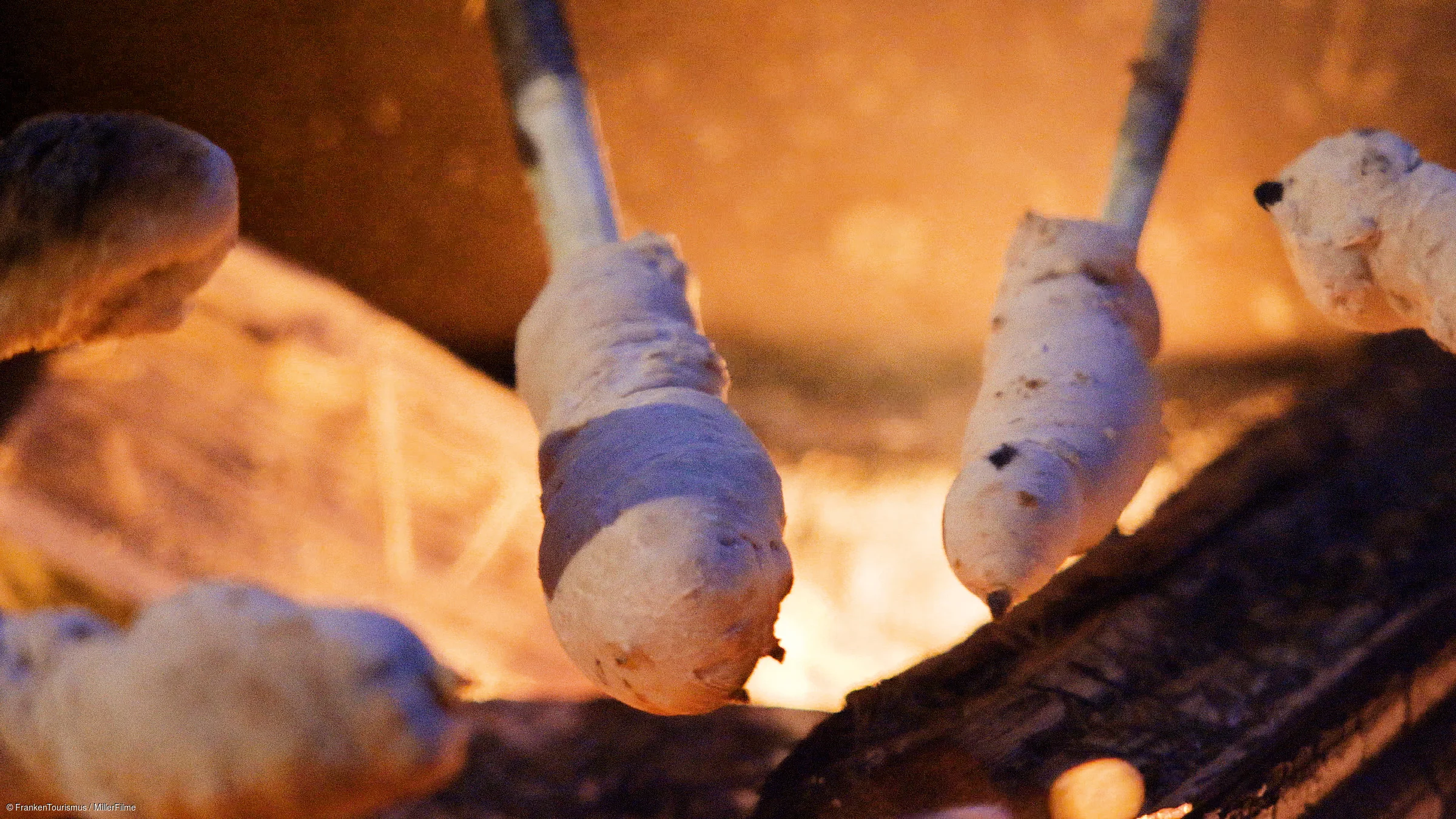 Stockbrot wird über offenem Feuer geröstet.