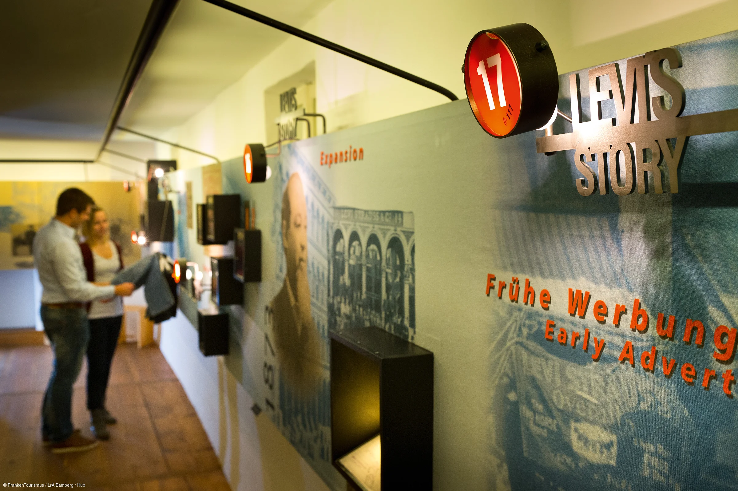 Museumsausstellung zur Geschichte von Levi's Jeans mit zwei Personen, die eine Jeans betrachten